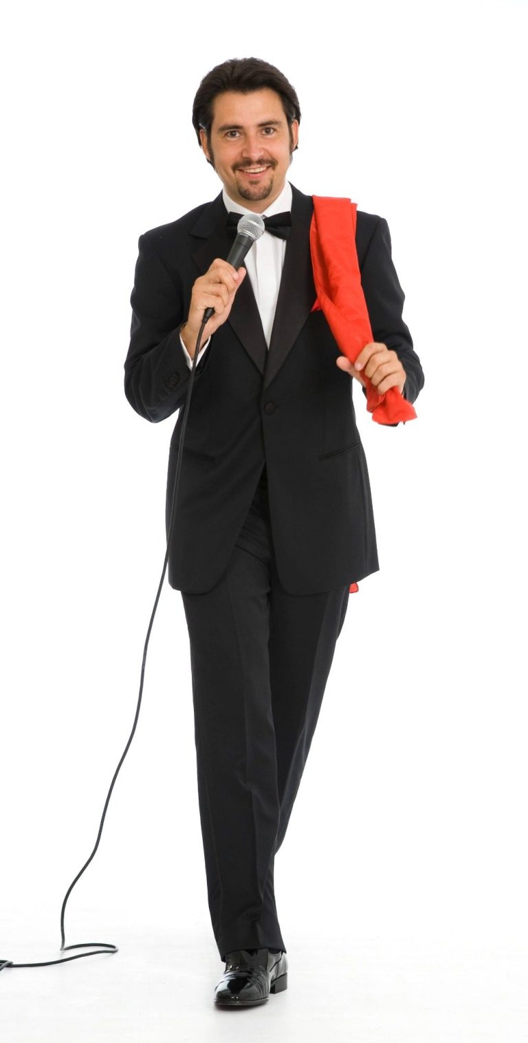 Mann als Sänger von Frank Sinatra Songs in elegantem Smoking mit Mikrofon und rotem Tuch über der Schulter.