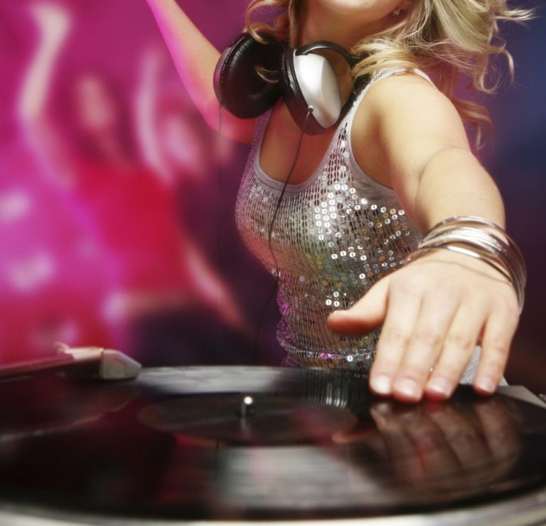 Schlager DJ mit Kopfhörern, die Schallplatte auf einem Plattenteller auflegt.