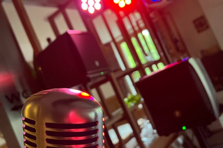 Retro Mikrofon und Lautsprecher vor buntem Bühnenlicht