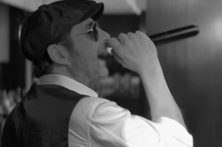 Italienischer Sänger mit Sonnenbrille und Mikrofon