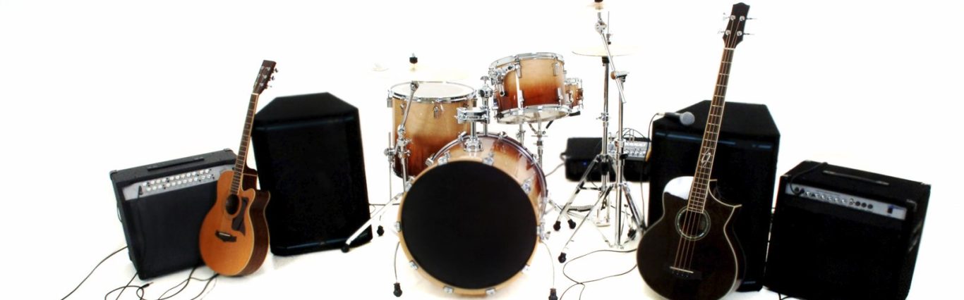 Schlagzeug und zwei E-Gitarren vor schwarzen Verstärkern.
