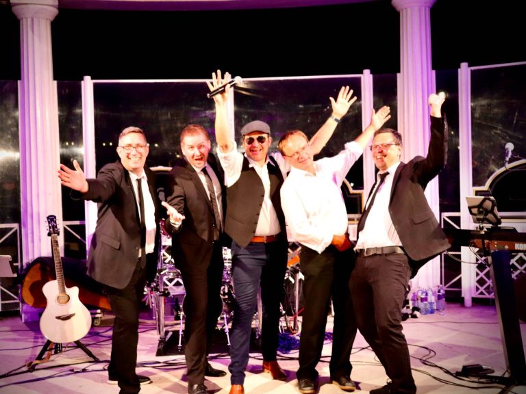 Italienische Band Italienische 5 Mann Band zusammen auf einer Bühne und alle Mitglieder zeigen mit den Händen nach oben